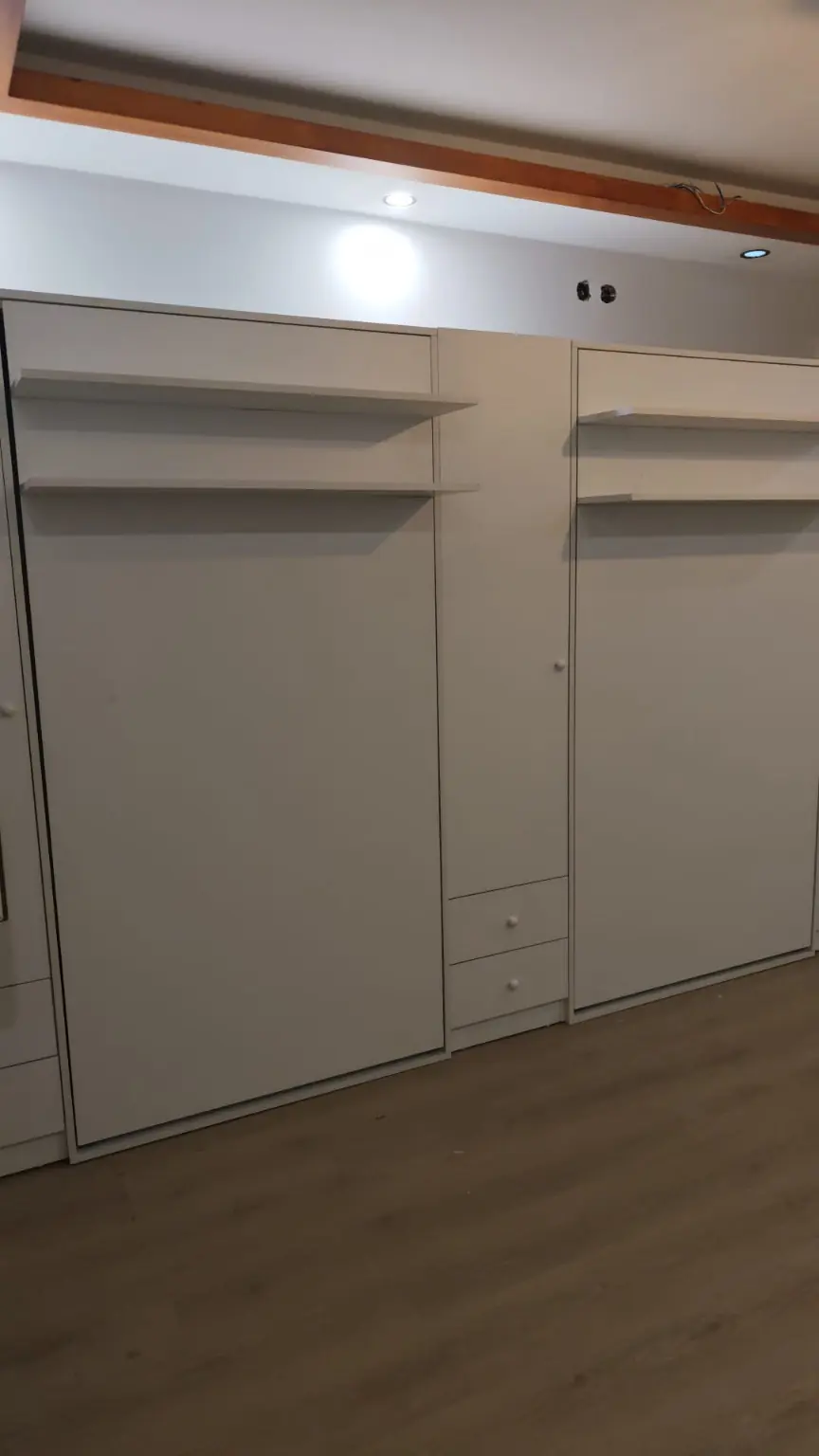 Beyaz çift katlanır yatak ve raflı dolap sistemi