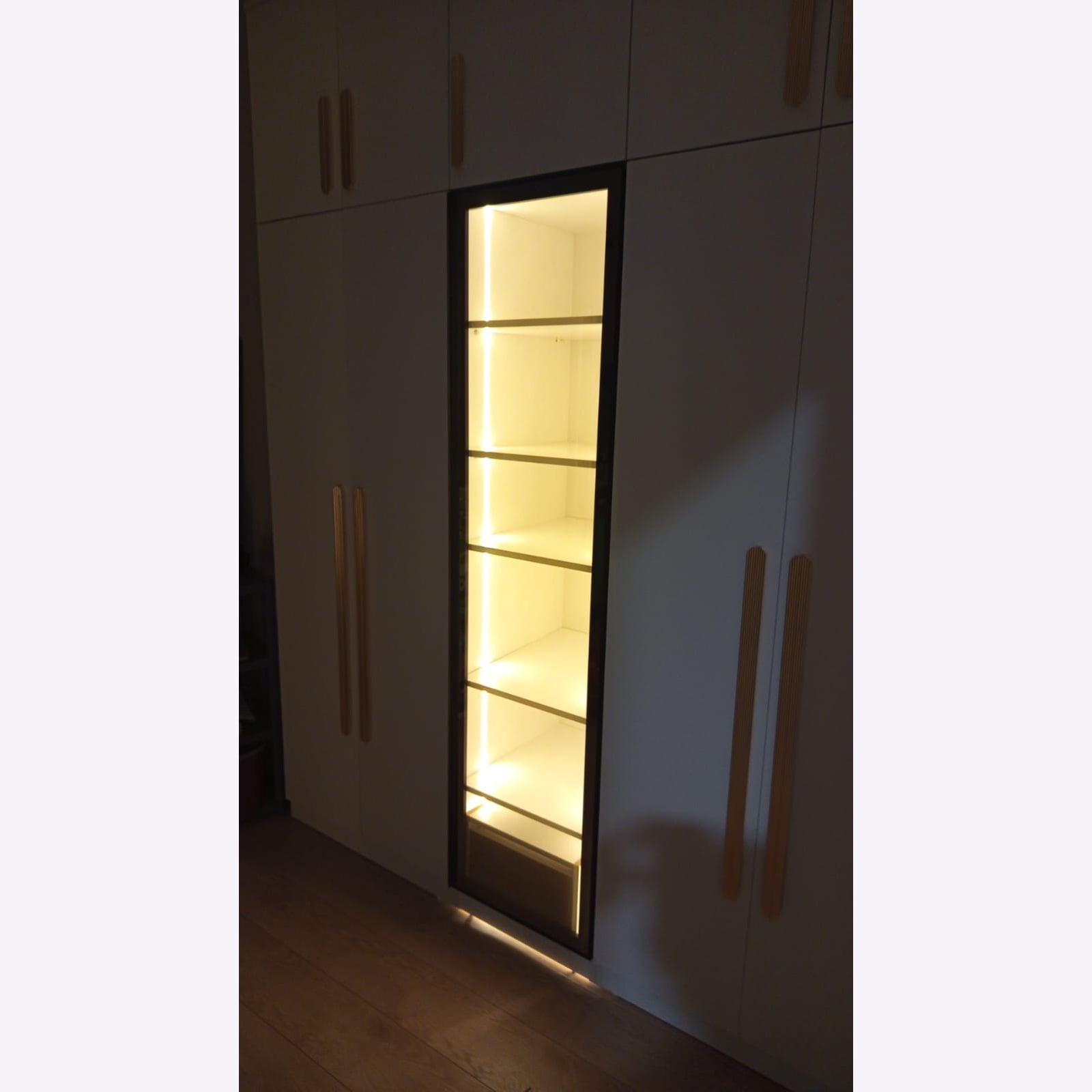 Bronz reflekte camlı gardıropta LED aydınlatmanın loş ortam görünümü