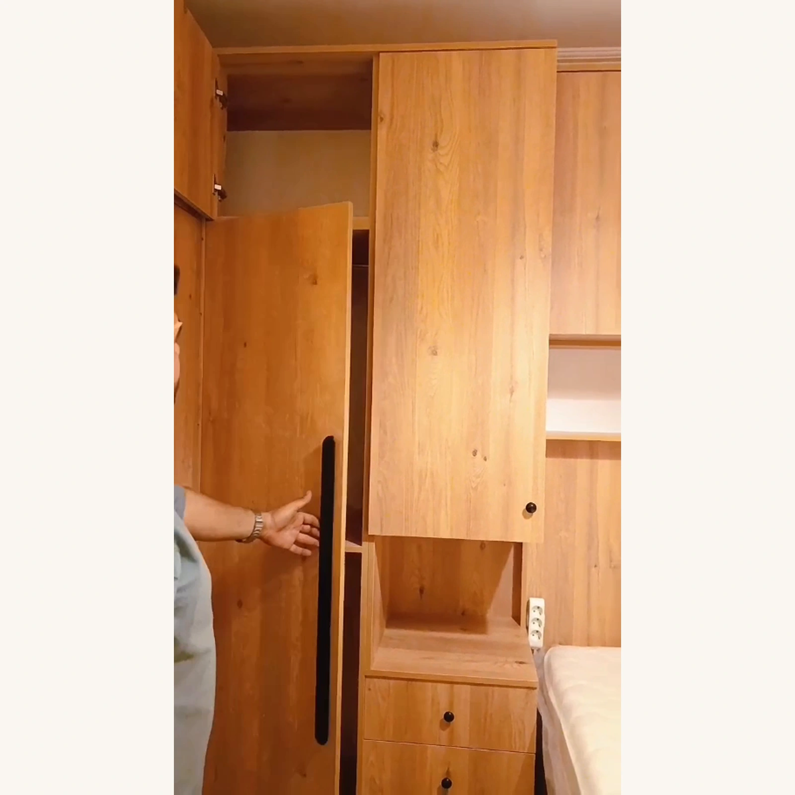 Meşe renk MDF boy dolabında uzun siyah kulp ve açık kapak detayı